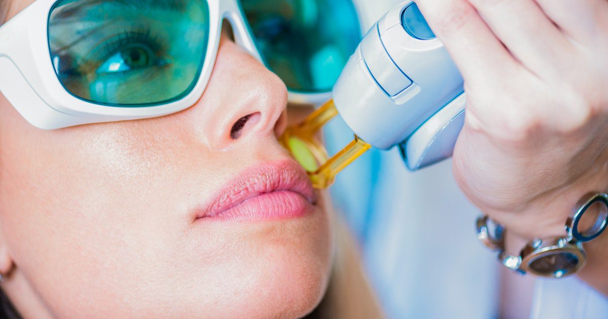 A woman in sunglasses is getting her lips waxed