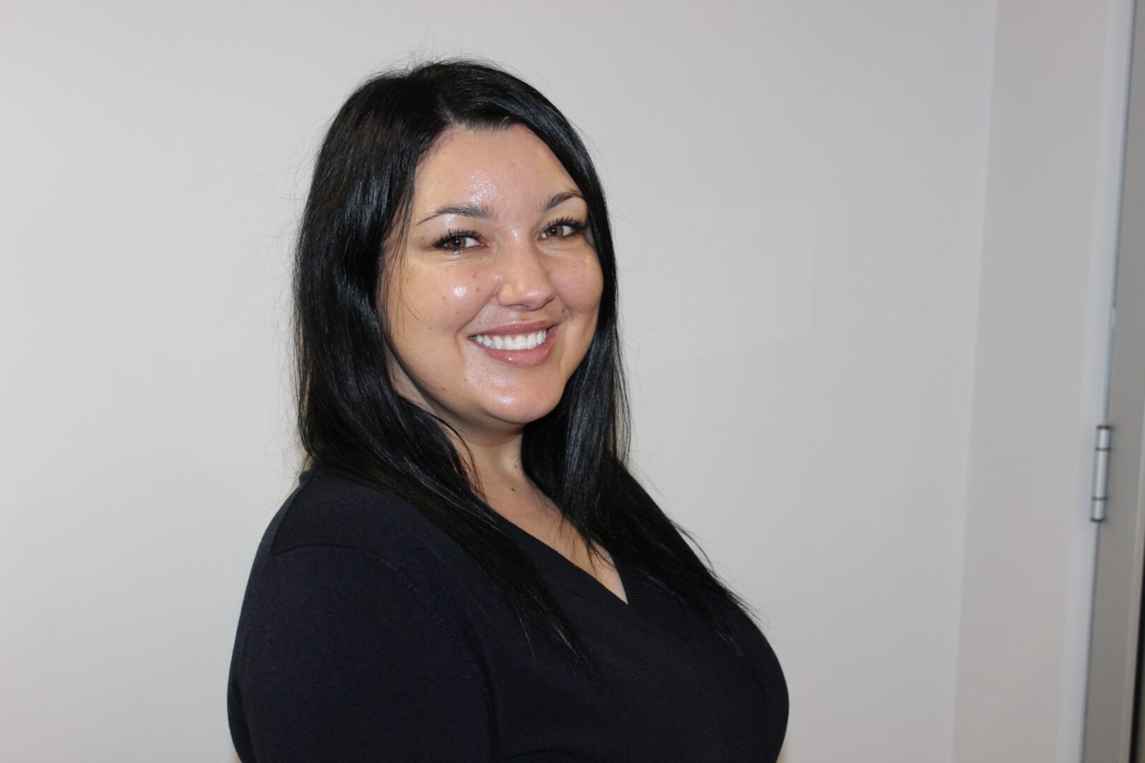 A woman in black shirt smiling for the camera.